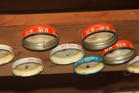 An Innovation from my past.  Some may call it a board with jar lids attached.  I call it the ceiling tool bench organizer.  Simply fill jars with items like nails or screws and attach jars to the appropriate lid.  Voila - organized and stored.